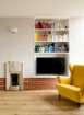 Living space with original art deco fire place, built in shelving and brick plinth