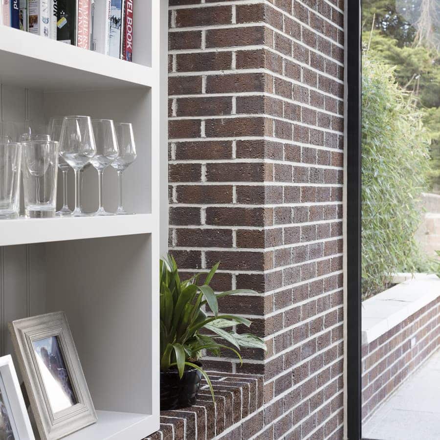 Brick ledge continues from outside to inside to form shelving unit