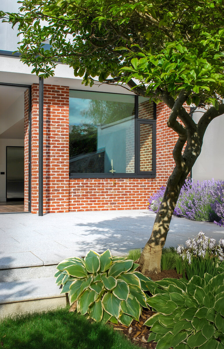 Architectural detail of rear garden elevation with patio outside contemporary extension