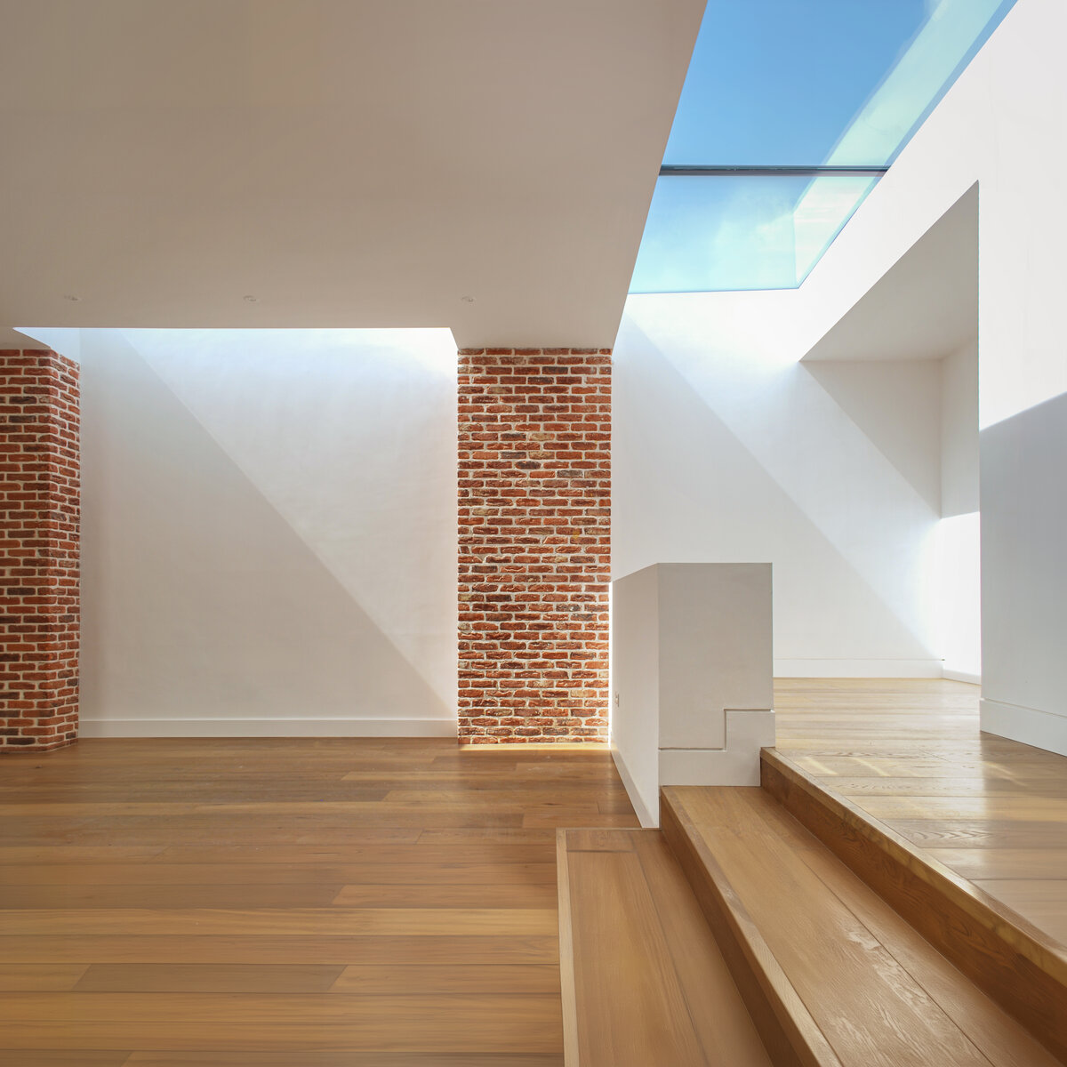 Dramatically daylit living room and raised playroom in contemporary addition to Victorian home