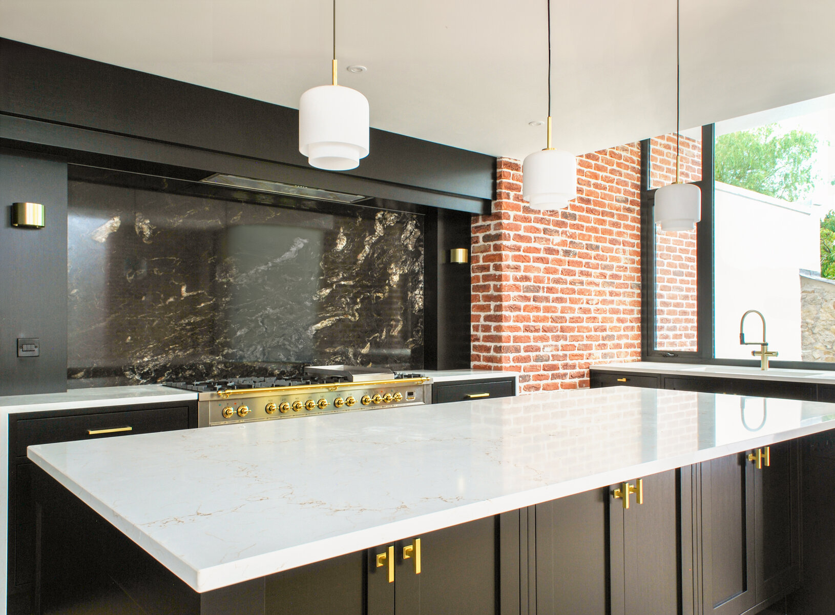 Contemporary kitchen with monochrome colour scheme and warm brickwork accents