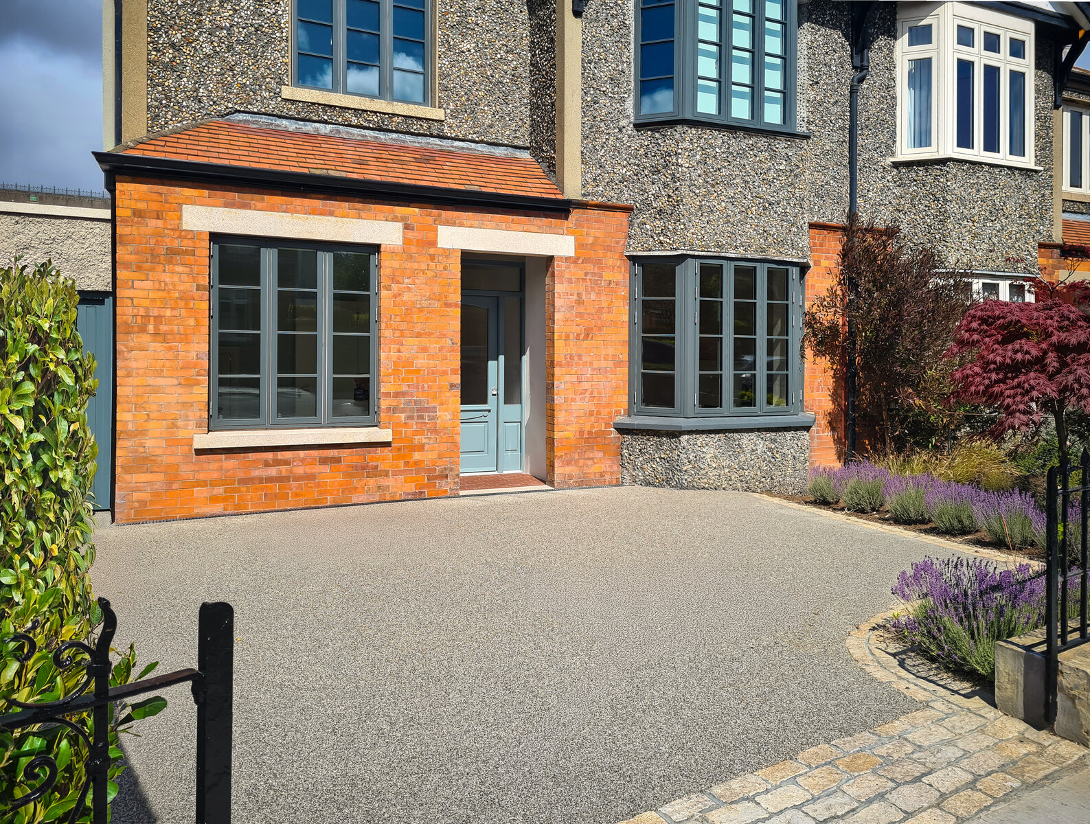 Resin entrance driveway and the front elevation of the renovated house showing new porch area and window to front of converted garage