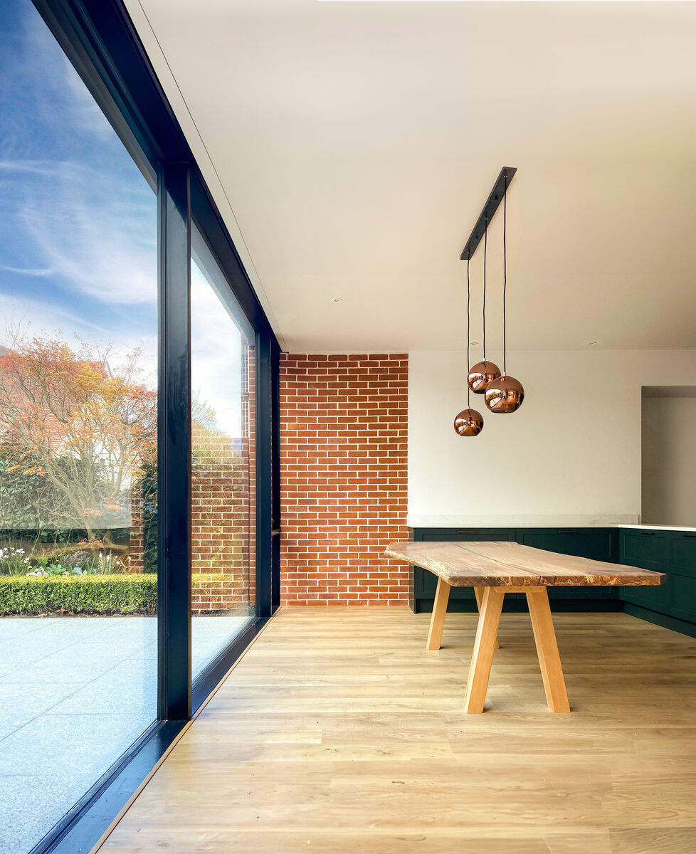 Interior view of the dining area with tall ceiling and views through to the rear courtyard garden