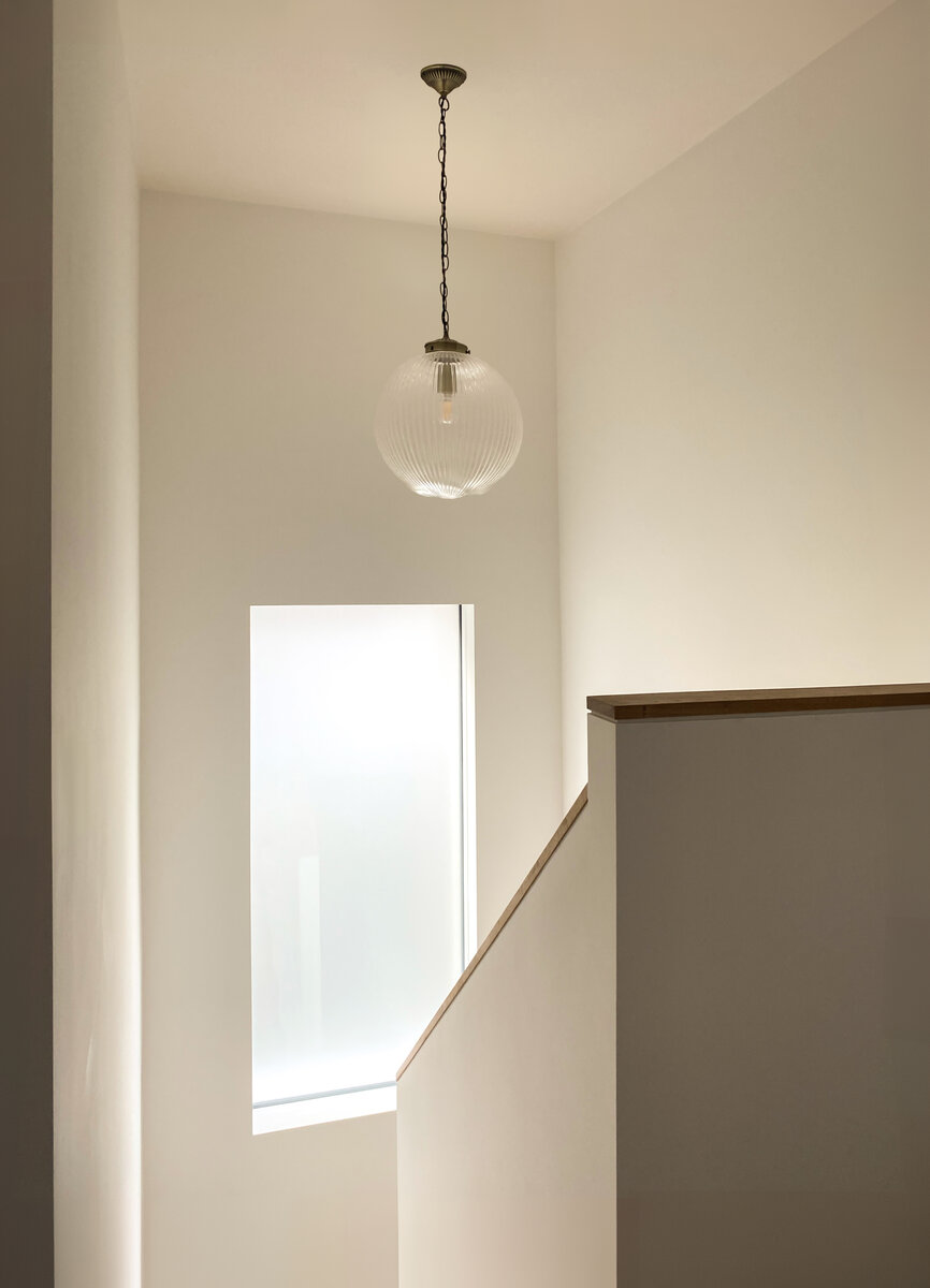 The old stairwell has been stripped back to the original structure with a large new window bathing the place in warm sunlight