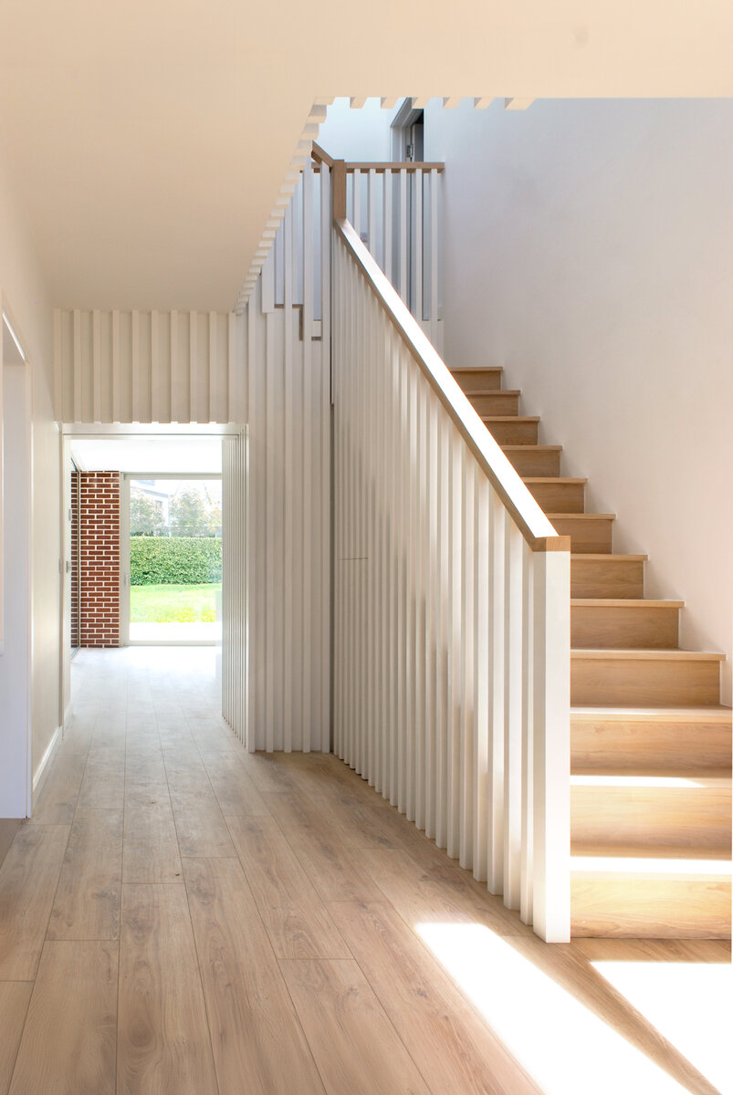 View through entrance hall with feature toplit staircase