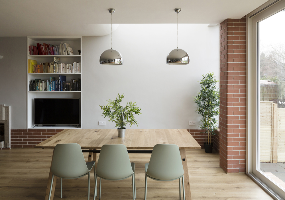 Toplit dining area with large table and brick piers